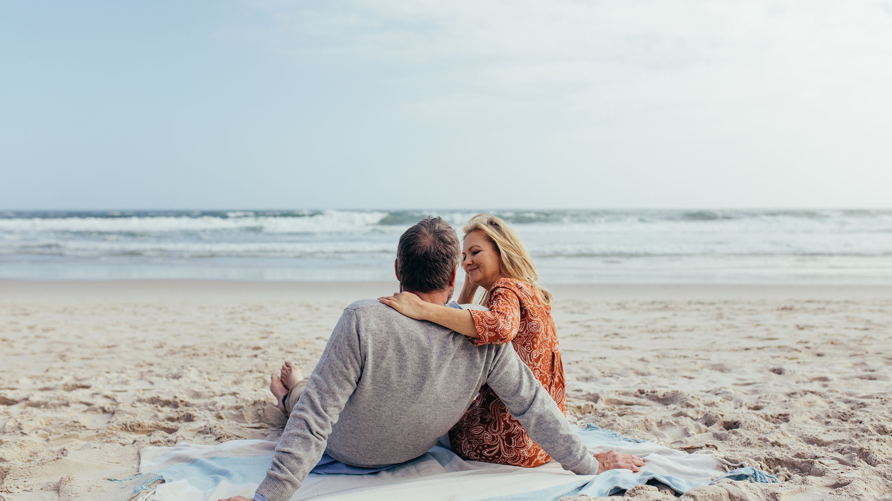 Couple relaxing on the beach reflecting peace of mind through personalized retirement and lifestyle planning