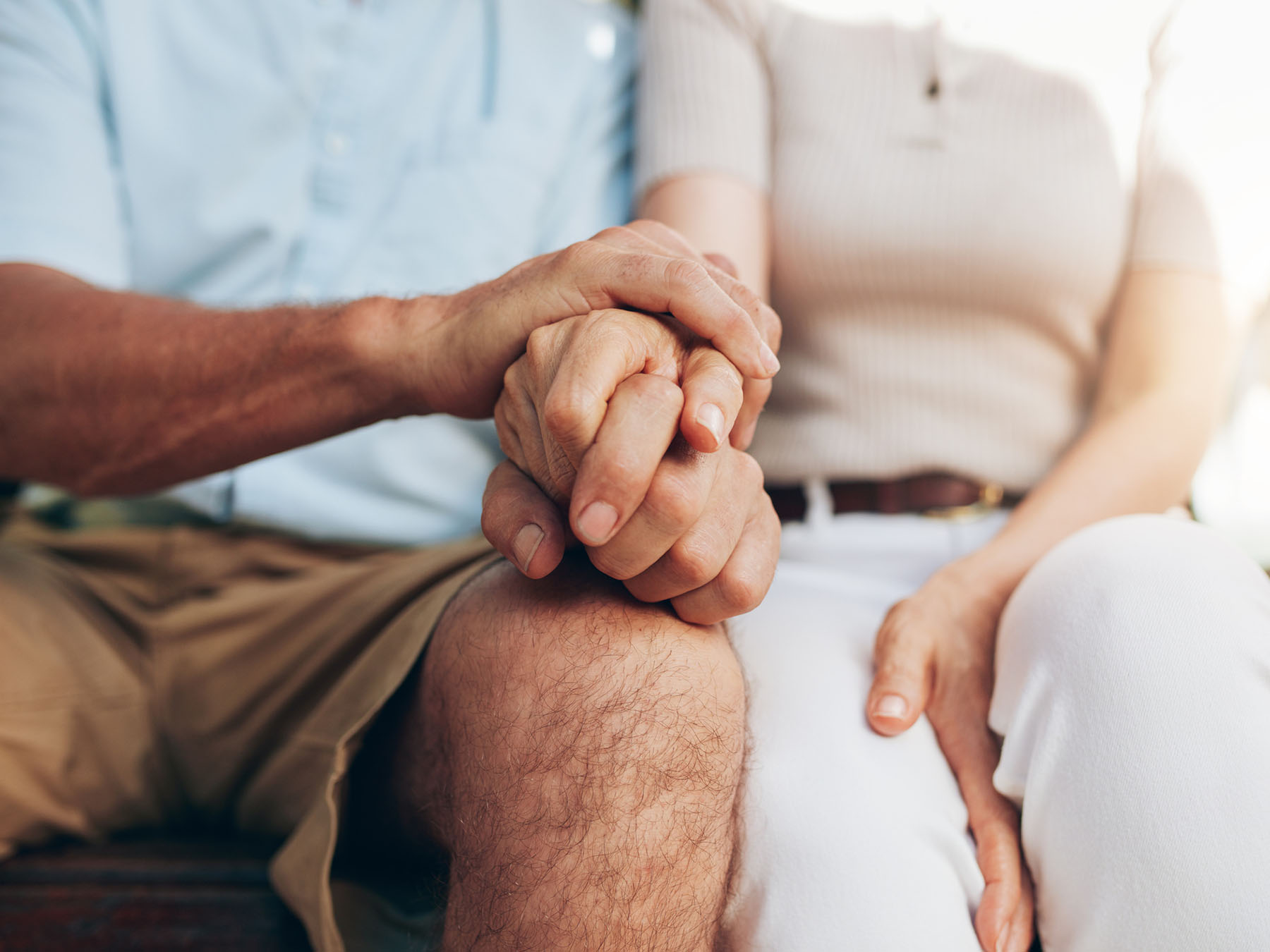 Close-up of couple holding hands symbolizing trust, connection, and decades-long financial partnerships