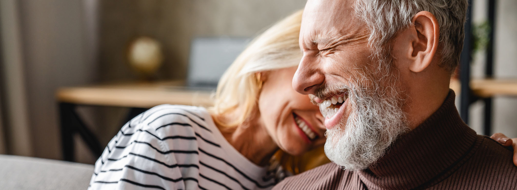 Older couple sharing a joyful moment representing trust and emotional connection in financial partnerships