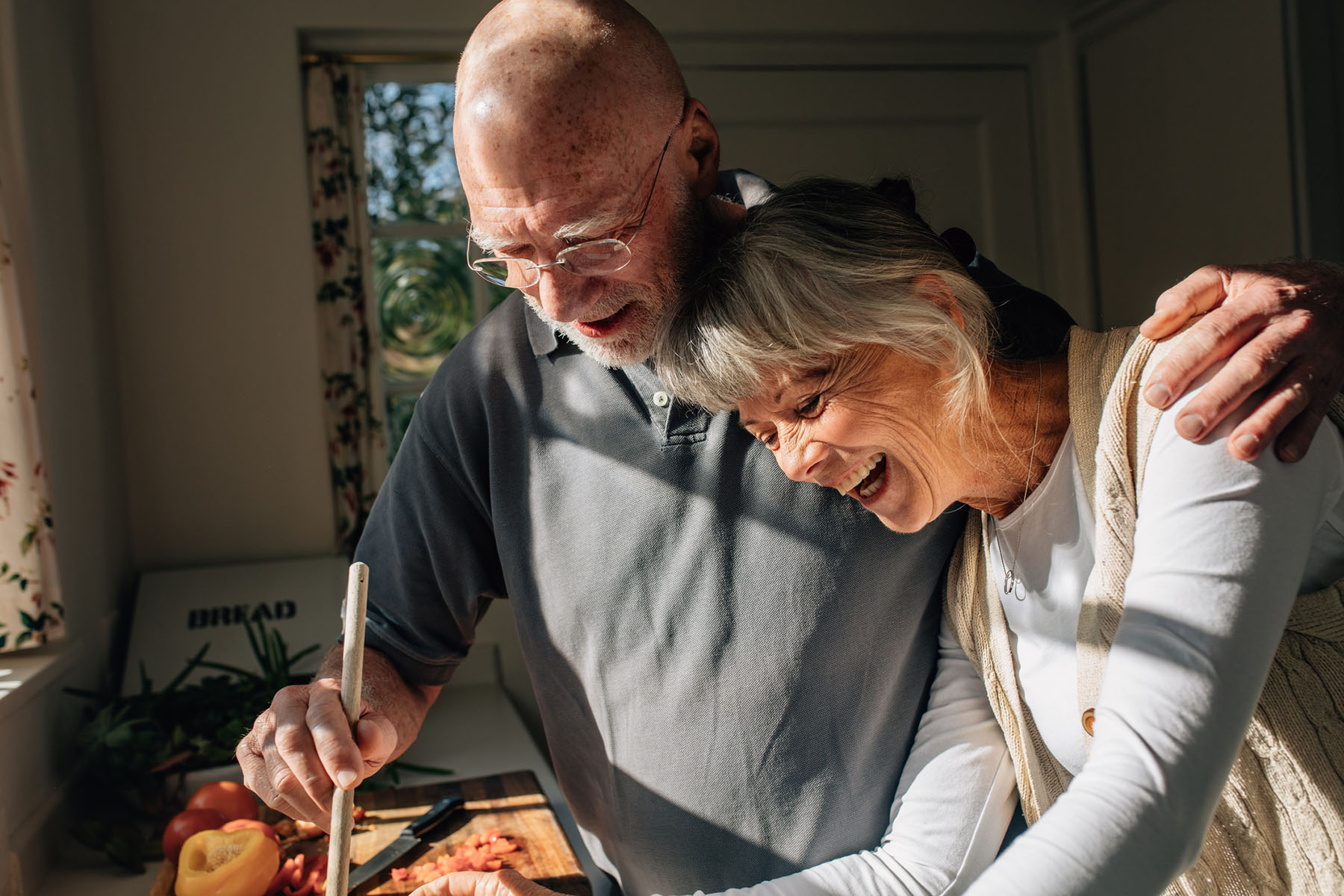 Older couple preparing food in kitchen highlighting life’s simple moments supported by thoughtful financial planning